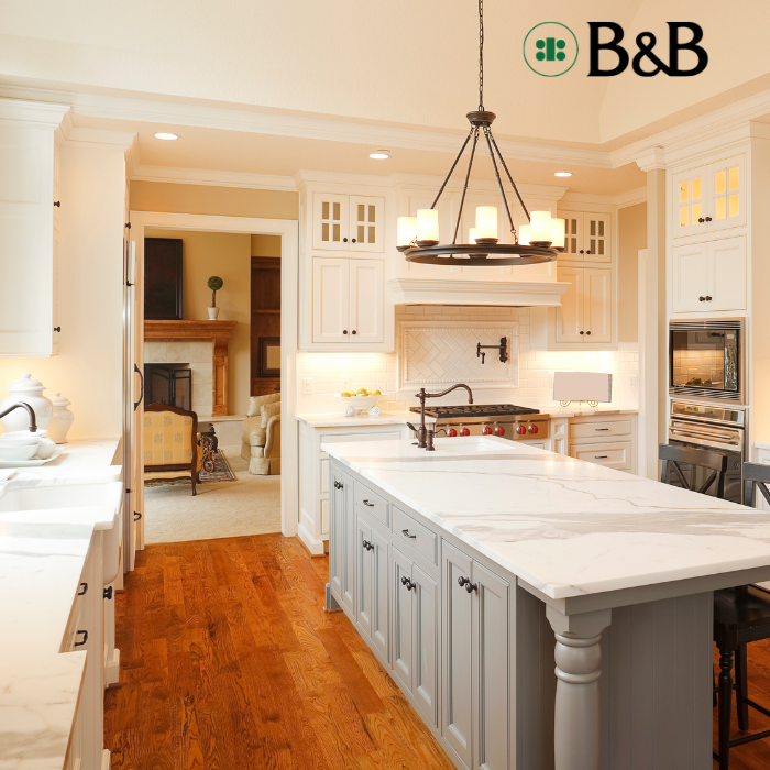 Kitchen with white cabinets and countertops with wooden flooring;.